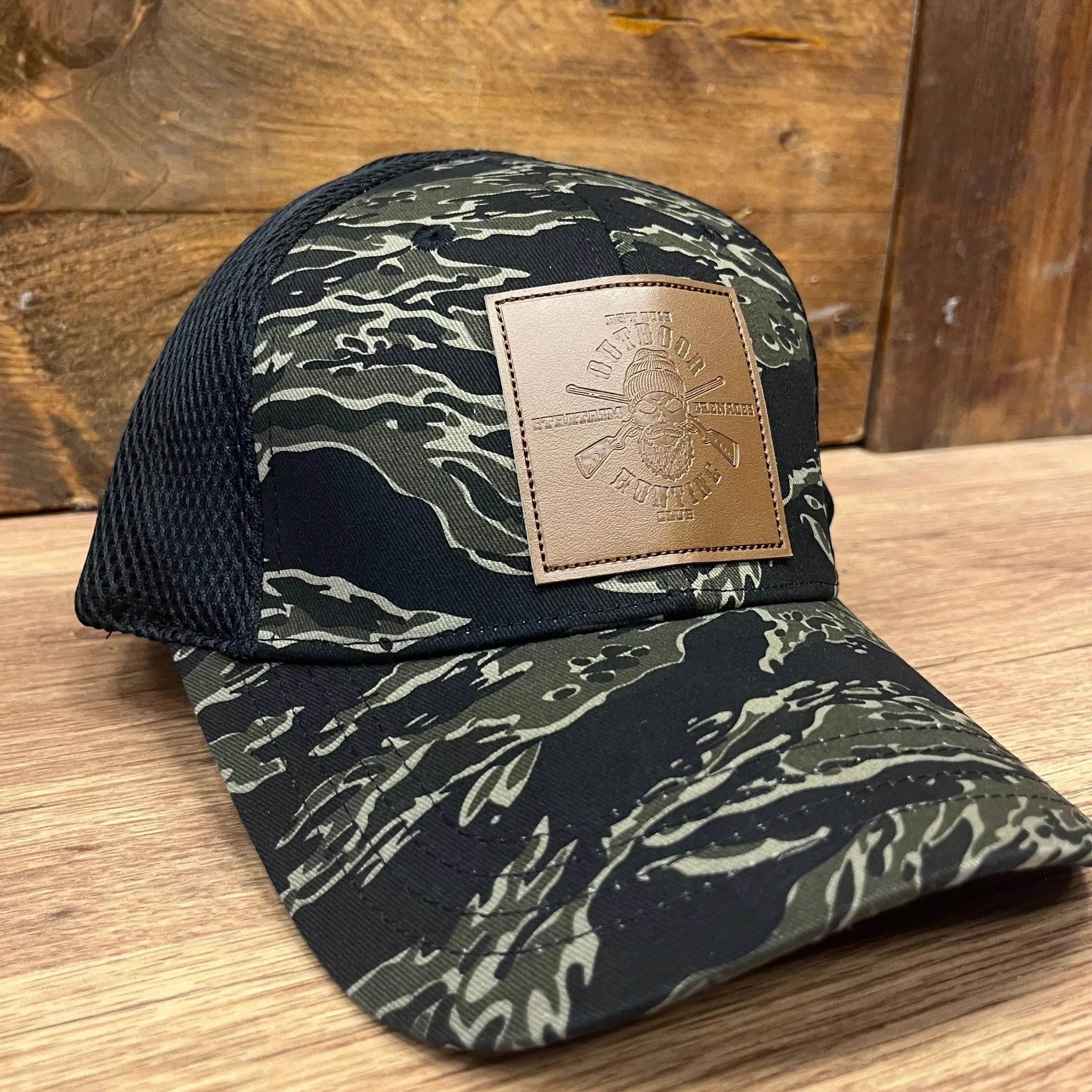 StratAIM Hunting Club Tigerstripe Baseball Cap on a wooden surface, highlighting the unique camo pattern.